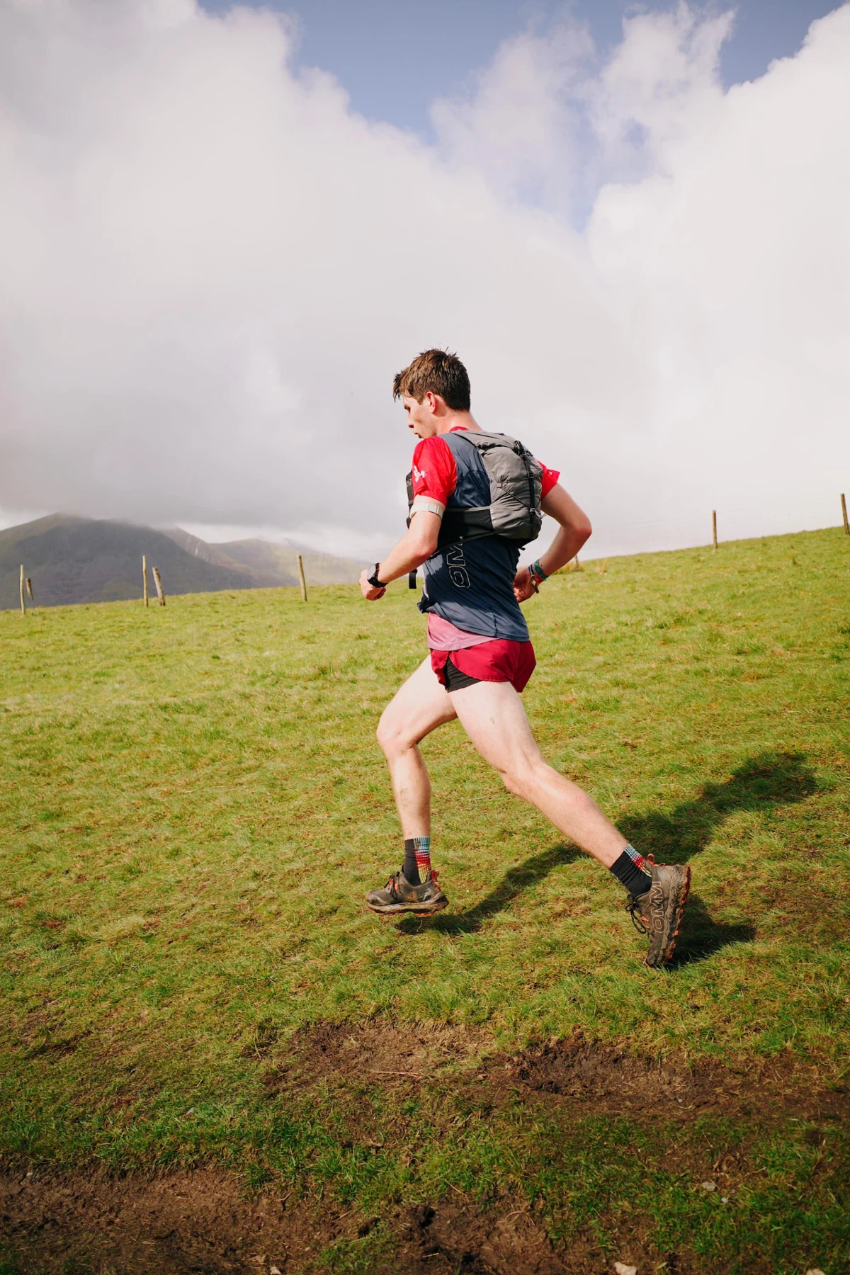Sam running across the mountain trails in red race kit
